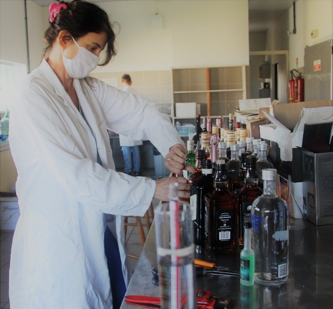 Professora Tania abrindo as bebidas recebidas como doação da Receita Federal.jpg