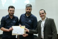 Diego Bassani e Henrique Alves Camargo recebem do diretor-geral, Alexandre Alfaro, o certificado de graduação no HT