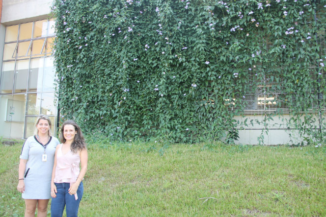 As professoras Ticiane e Cleila responsáveis pela pesquisa com a fachada verde no campus.jpg