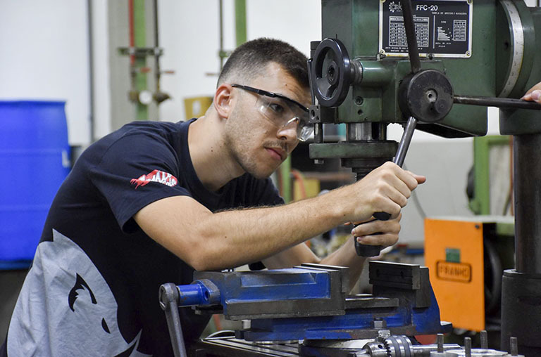 Aluno manipula equipamento mecânico