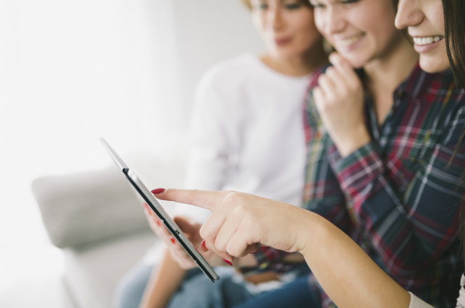 três meninas veem conferem resultado em tablet