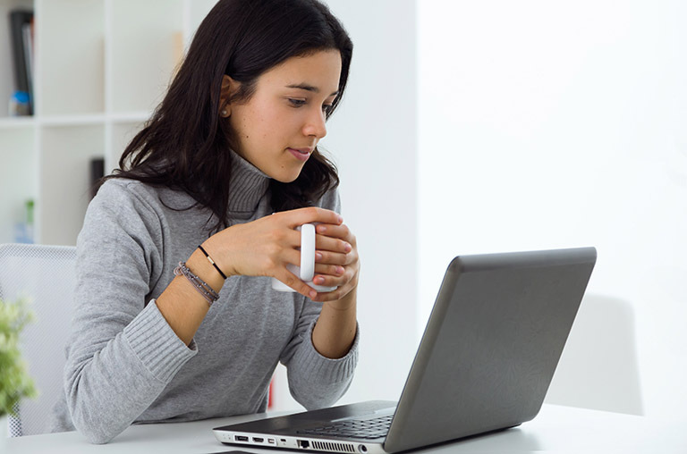 Mulher acessa a plataforma pelo notebook